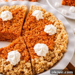 Whole pie of krispie treats in a pie plate, after cutting, on a marble table.
