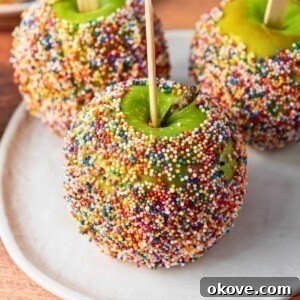 Green apples dipped in a coating and rolled in colorful sprinkles.