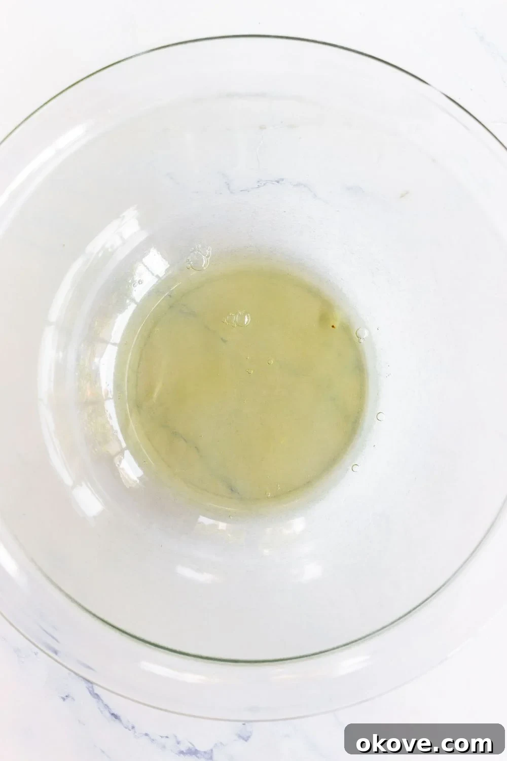Egg whites in a clear large glass bowl before being mixed. 