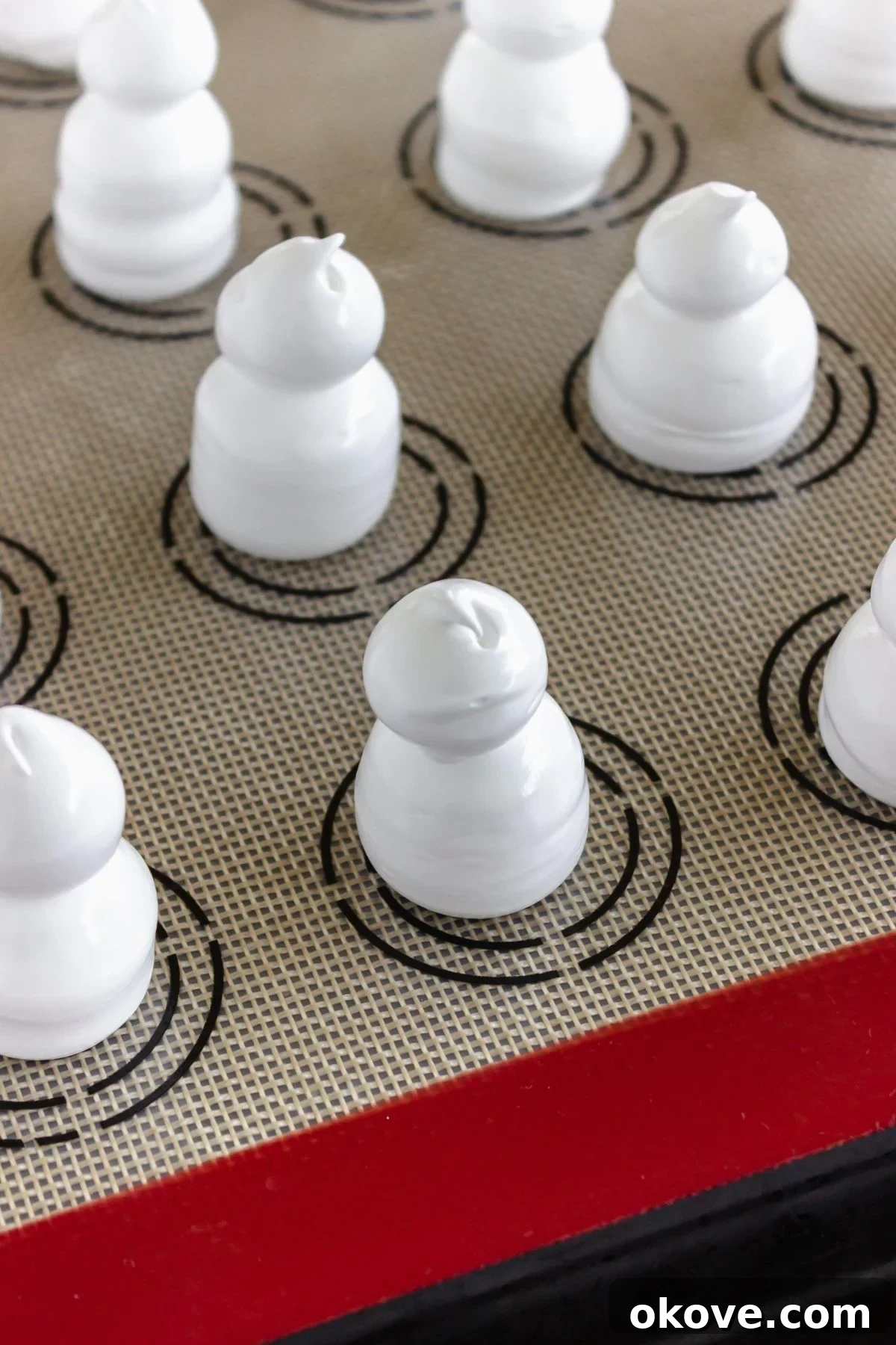 Meringues piped onto baking sheet lined with silicone baking sheet liner. 