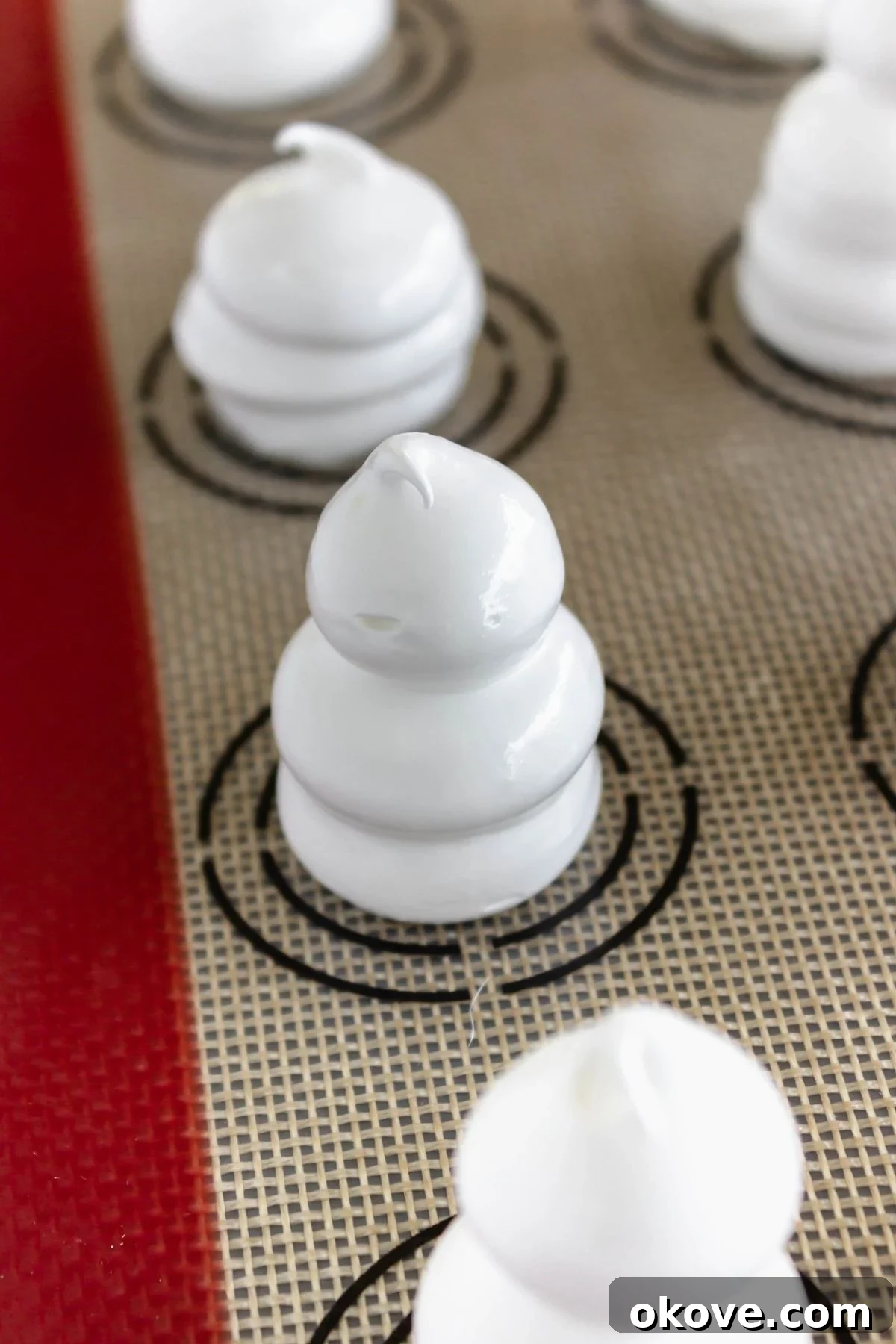 Meringues piped onto baking sheet lined with silicone baking sheet liner. 