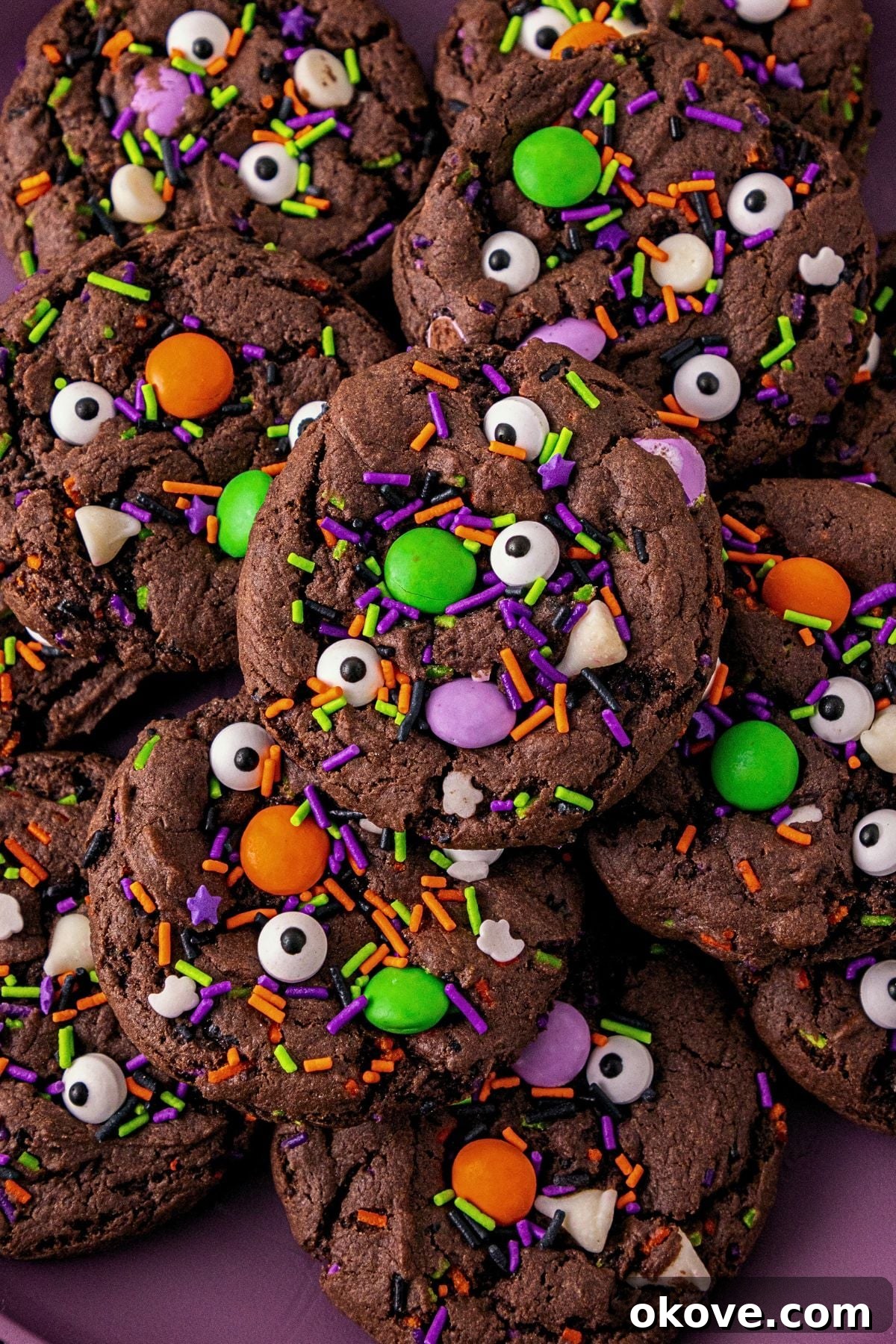 Chocolate cake mix cookies with sprinkles and candies mixed in, on a purple plate. 