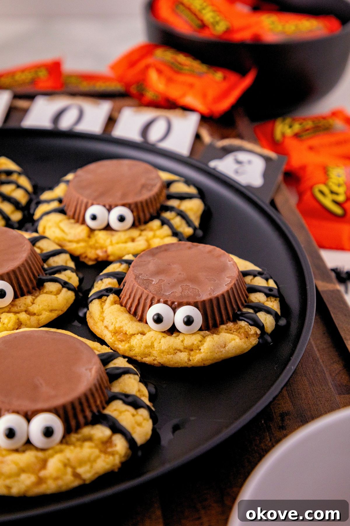 Spider cookies made with cake mix, topped with Reese’s peanut butter cups, candy eyes, and chocolate spider legs for an easy Halloween treat.