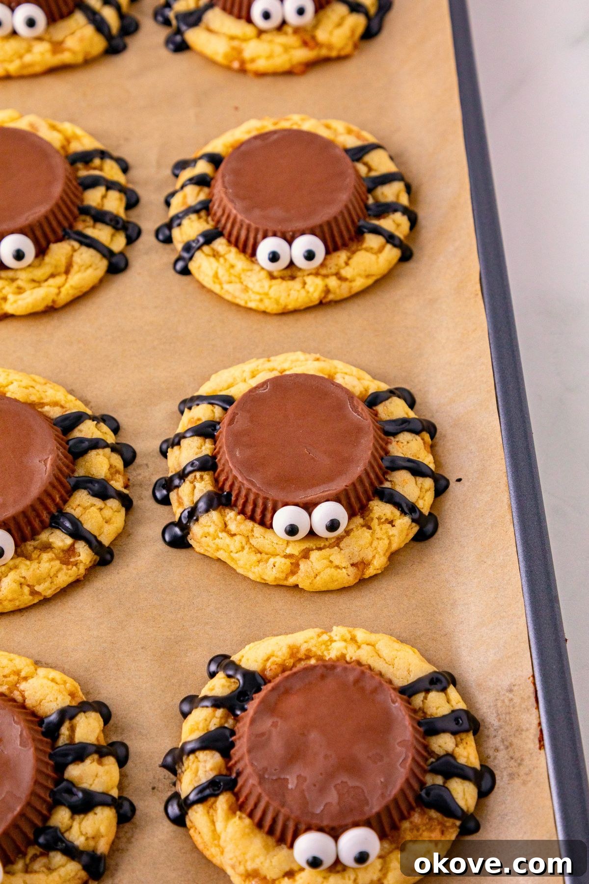 Baked cookies with a peanut butter cup placed on top of each cookie for the spider body and candy eyes. 