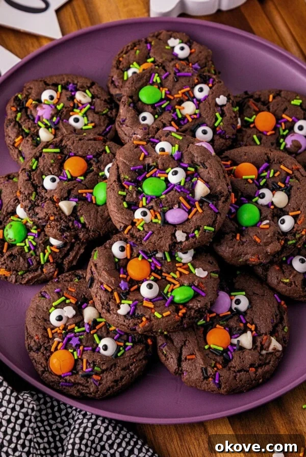 Chocolate cake mix cookies with sprinkles and candies mixed in, on a purple plate.