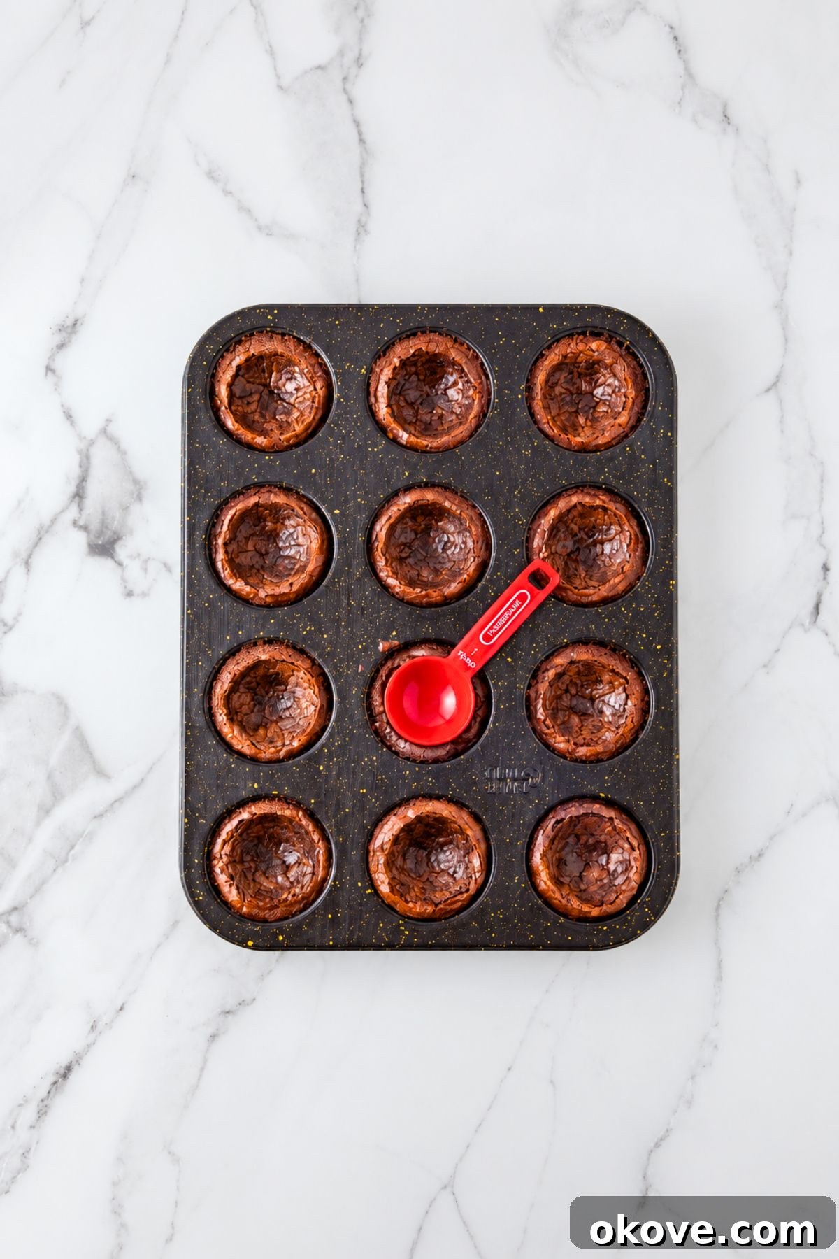 Baked brownie bites with the center pressed in with a spoon. 